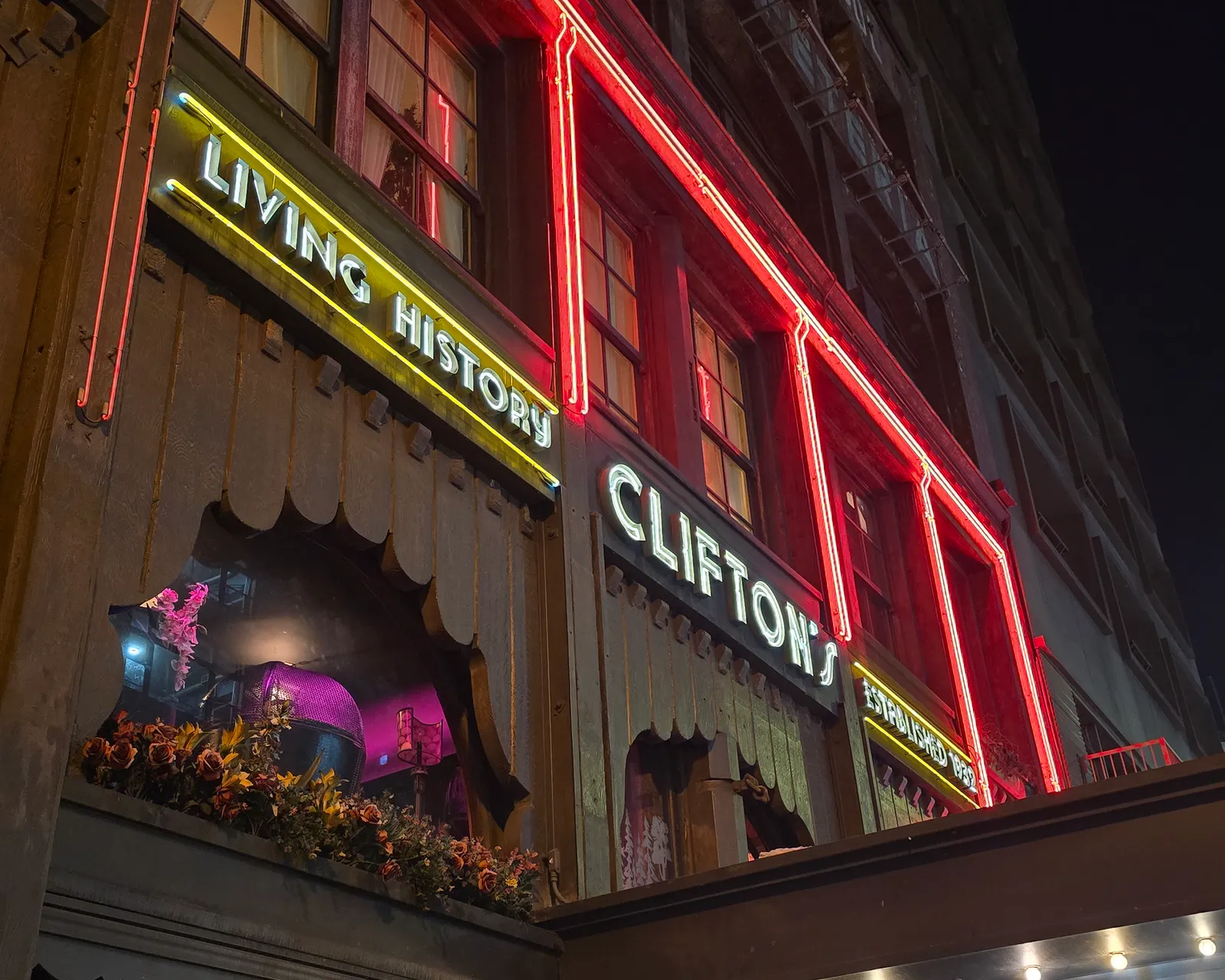 The Clifton’s neon sign lit red and gold against the night on Broadway.